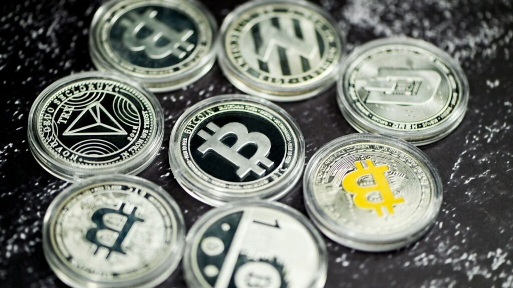 مجموعة عملات بيتكوين تذكارية فضية اللون مرصوفة على سطح رخامي داكن